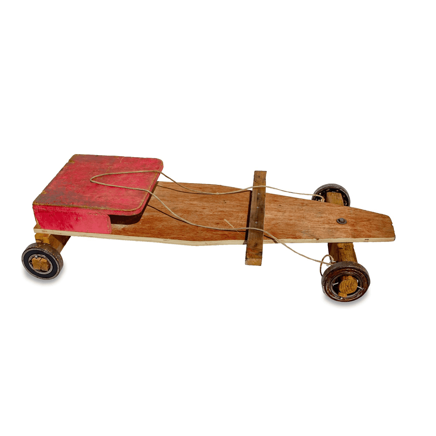 photo d'une planche de bois avec 4 roues, assez grande pour que quelqu'un puisse s'asseoir dessus.